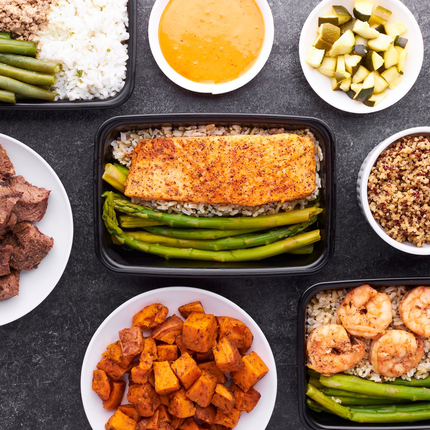 Bereide maaltijden met zalm, garnalen, rundvlees, quinoa en groente in porties